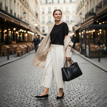 Femme portant un sac cabas cuir noir élégant dans une rue urbaine