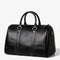 Vue de face du sac de voyage en cuir noir avec bandoulière réglable