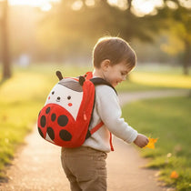Sac à dos maternelle en peluche coccinelle porté par un enfant en extérieur