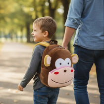 Enfant portant un sac à dos maternelle en peluche singe en extérieur