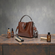 Sac à main en cuir véritable brun posé sur une table avec accessoires d’entretien du cuir, illustrant la durabilité et le soin des sacs en cuir haut de gamme.