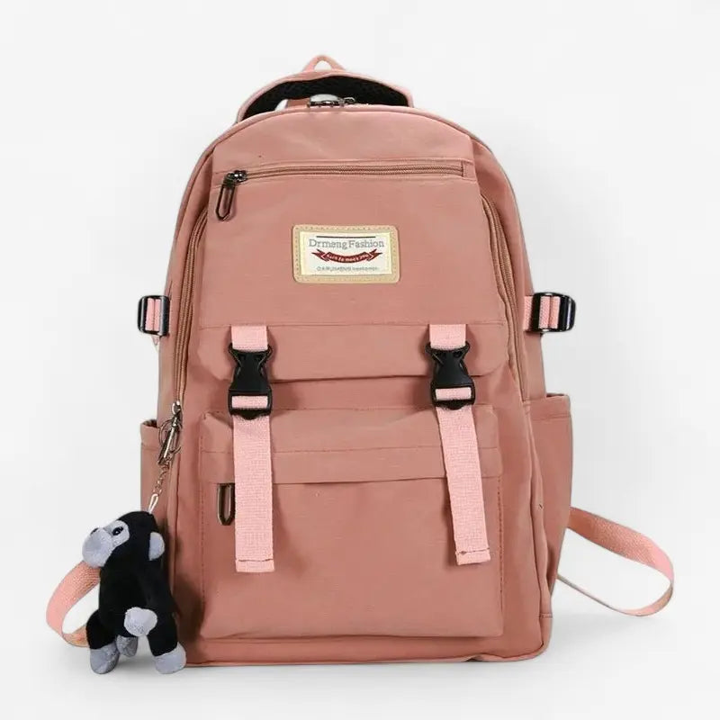 Vue de face du sac à dos lycée rose unisexe avec peluche orang-outan accrochée