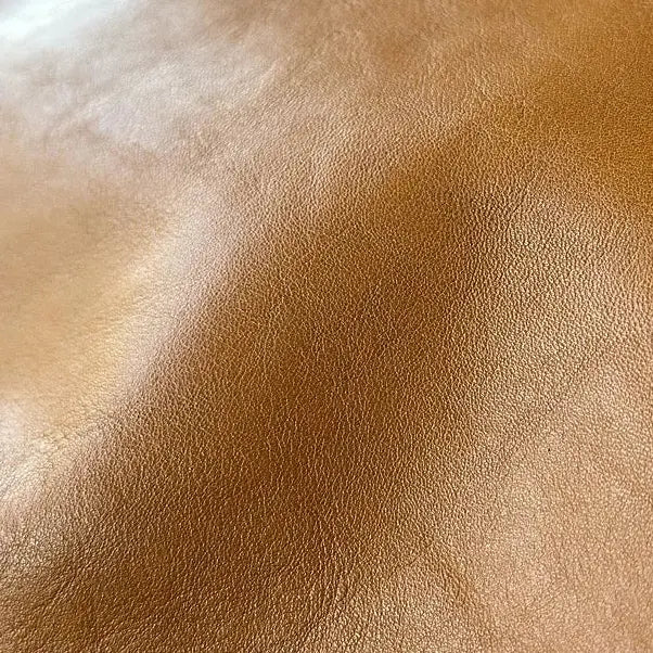 Gros plan sur la texture du cuir cognac du sac cabas