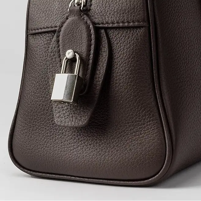 Fermeture zippée du sac bowling en cuir grainé marron avec cadenas antivol