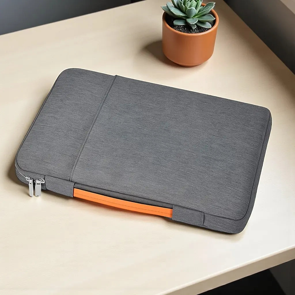 Housse ordinateur portable grise posée sur une table en bois avec plante décorative