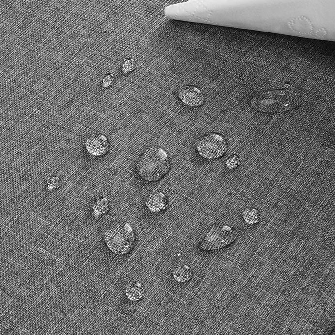 Gros plan sur tissu imperméable de housse ordinateur portable grise avec gouttes d’eau