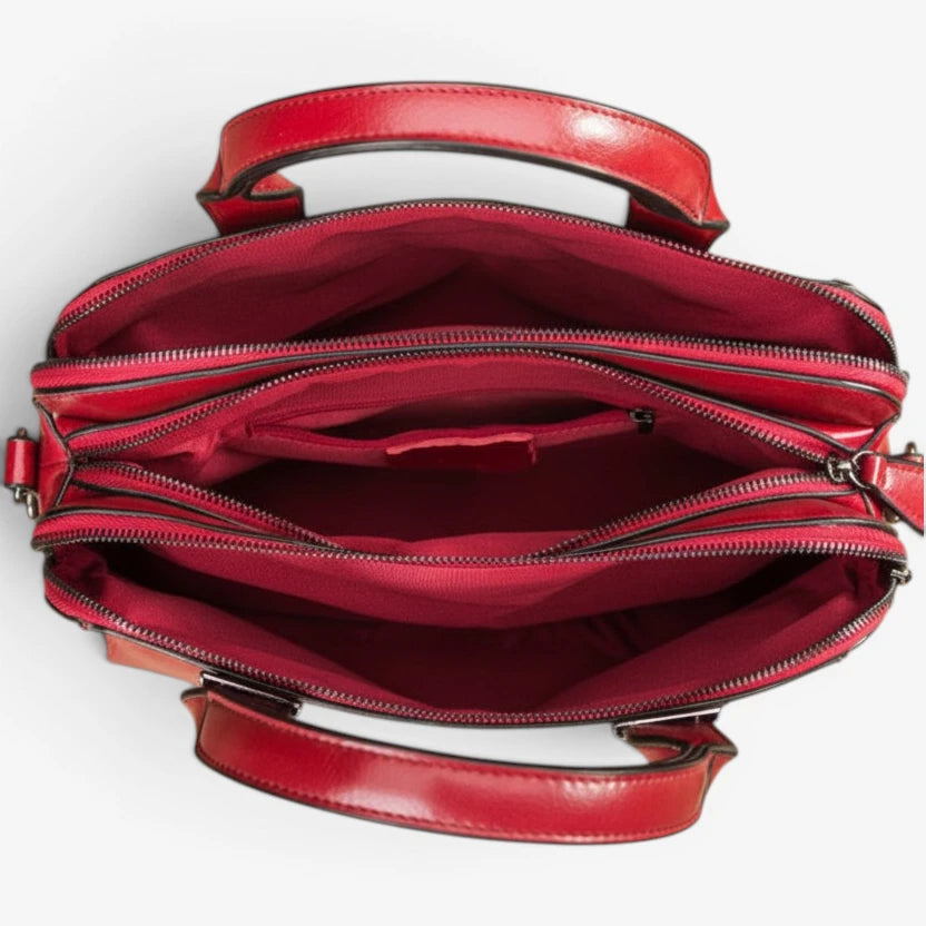 Intérieur du sac en cuir rouge avec plusieurs compartiments de rangement zippés