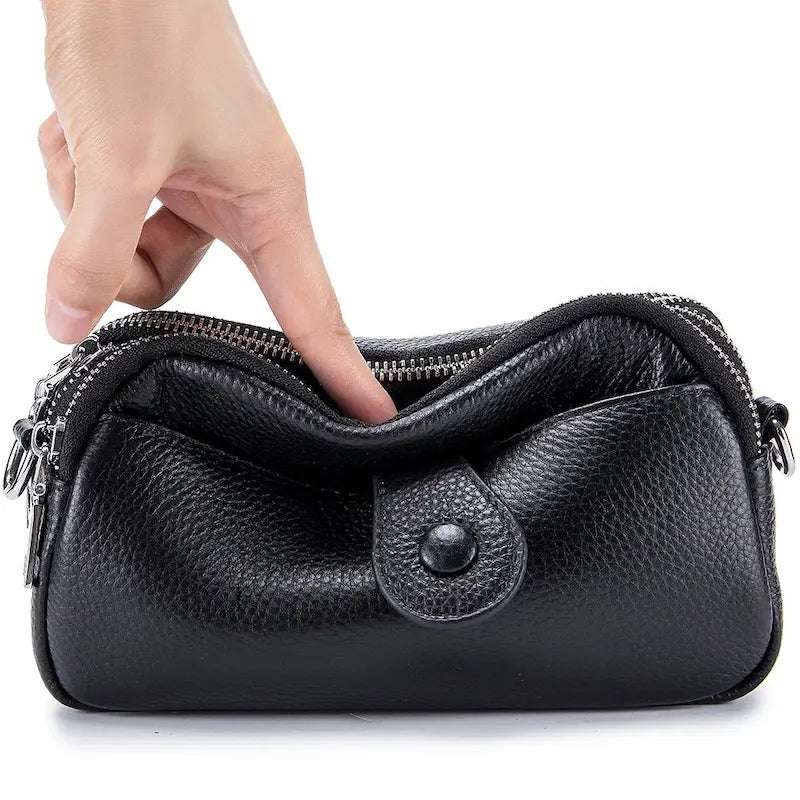 Petit sac en cuir véritable noir tenu à la main avec poche frontale