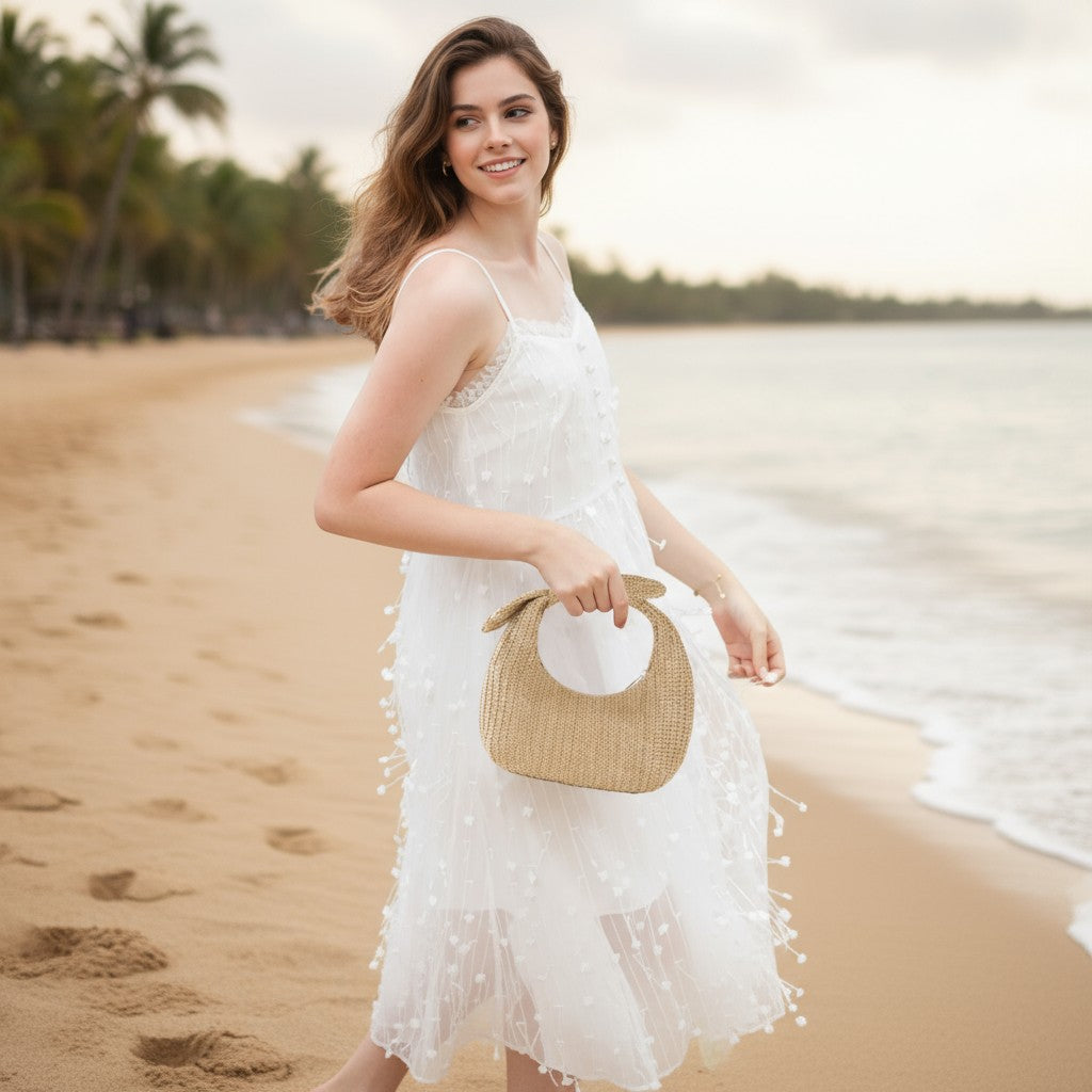 Pochette bohème en paille avec nœud portée avec robe blanche, style chic