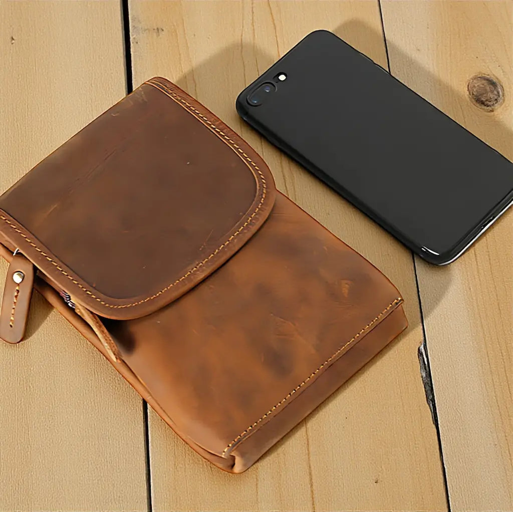 Pochette en cuir marron vintage avec smartphone en comparaison de taille