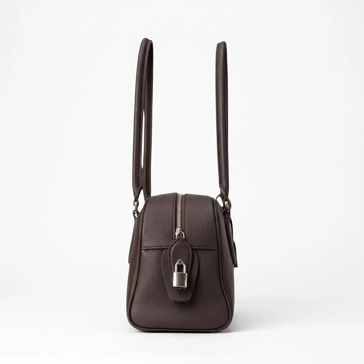 Vue de profil du sac bowling en cuir grainé marron avec longues anses