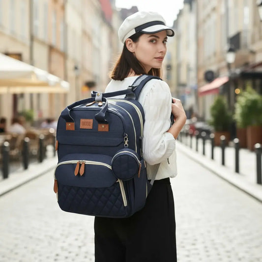 sac à dos à langer 3 en 1 bleu porté par une femme marchant en ville