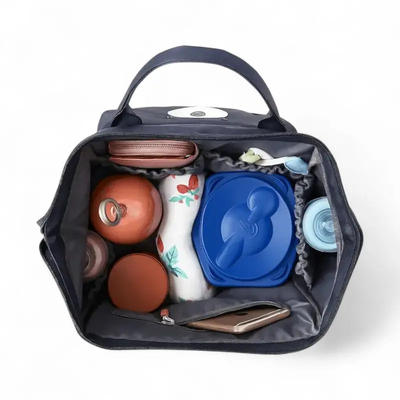 Sac à dos à langer bleu vu de dessus avec accessoires et biberons rangés