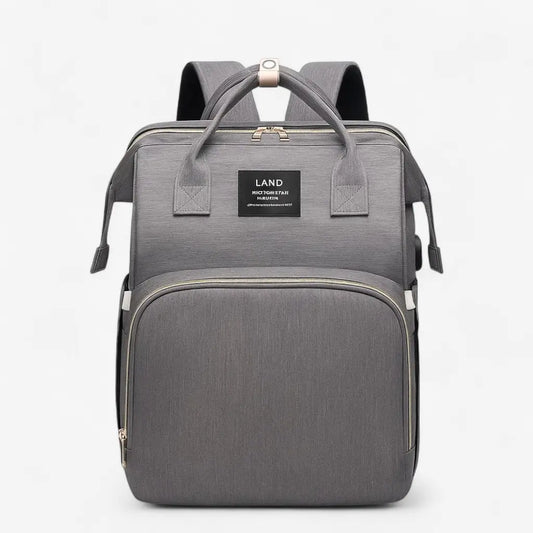 Sac à dos à langer gris avec lit intégré, poche avant zippée fermée, vue de face