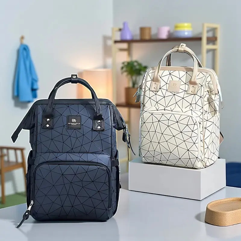 Sac à dos à langer noir et beige géométrique présenté côte à côte