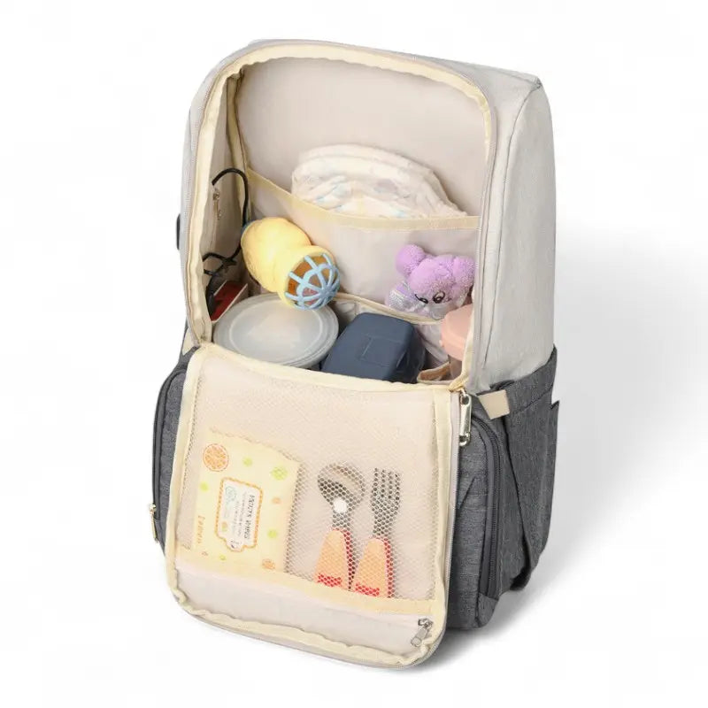 Intérieur du sac à dos à langer USB montrant les rangements et biberons organisés