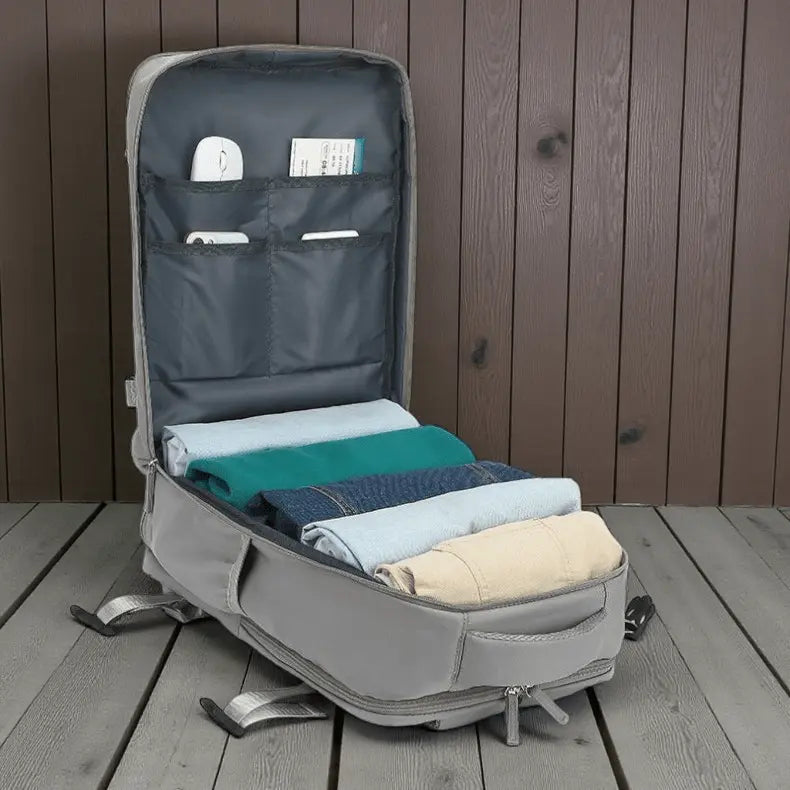 Sac à dos cabine avion rose ouvert avec vêtements pliés à l’intérieur, rangements bien structurés