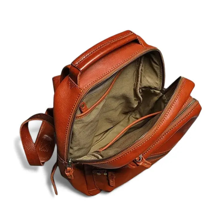 Vue intérieure du sac à dos en cuir marron montrant les compartiments et la doublure