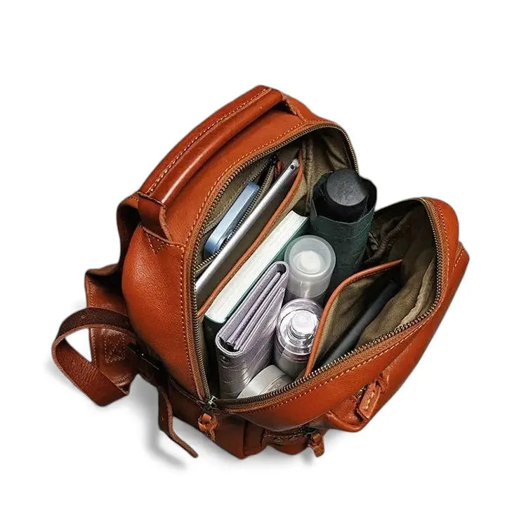 Intérieur du sac à dos en cuir marron avec rangements pour bouteille, accessoires et essentiels