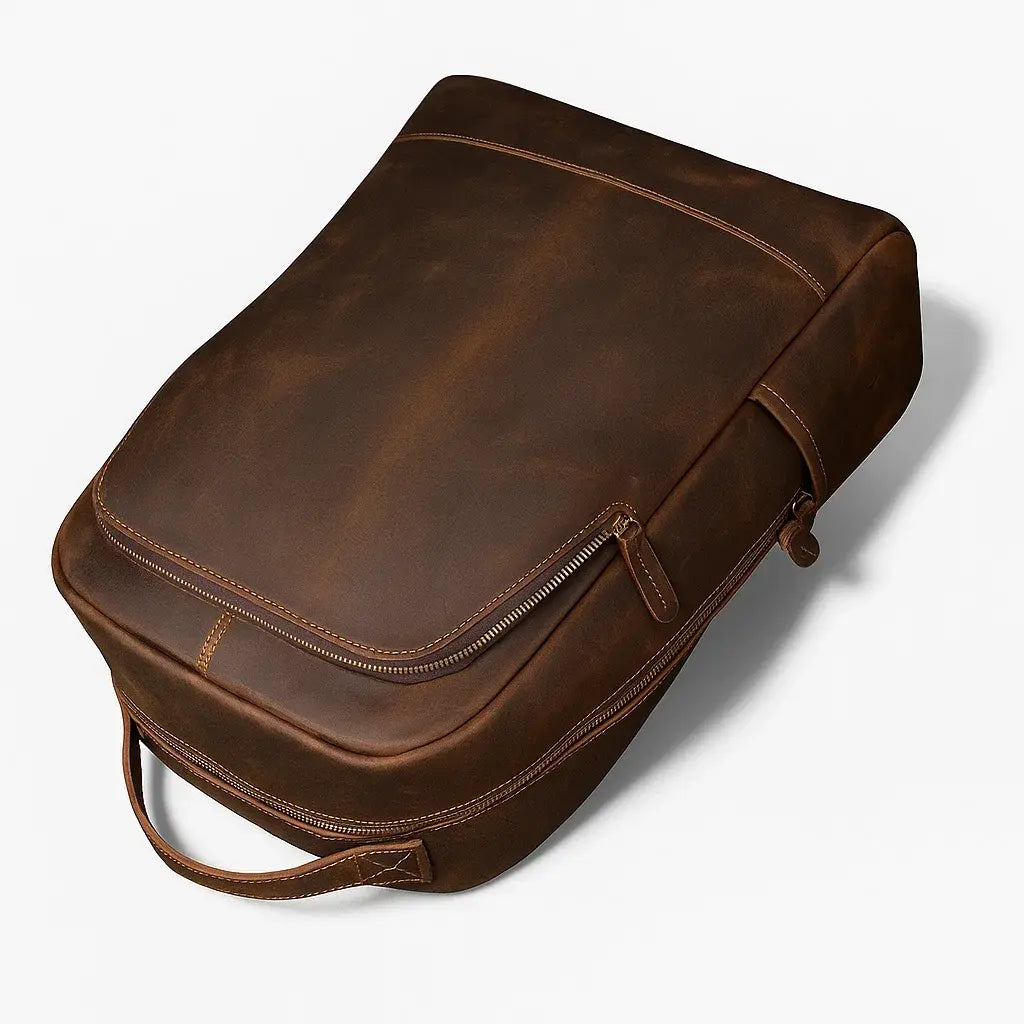 Sac à dos en cuir marron vu en perspective posé au sol