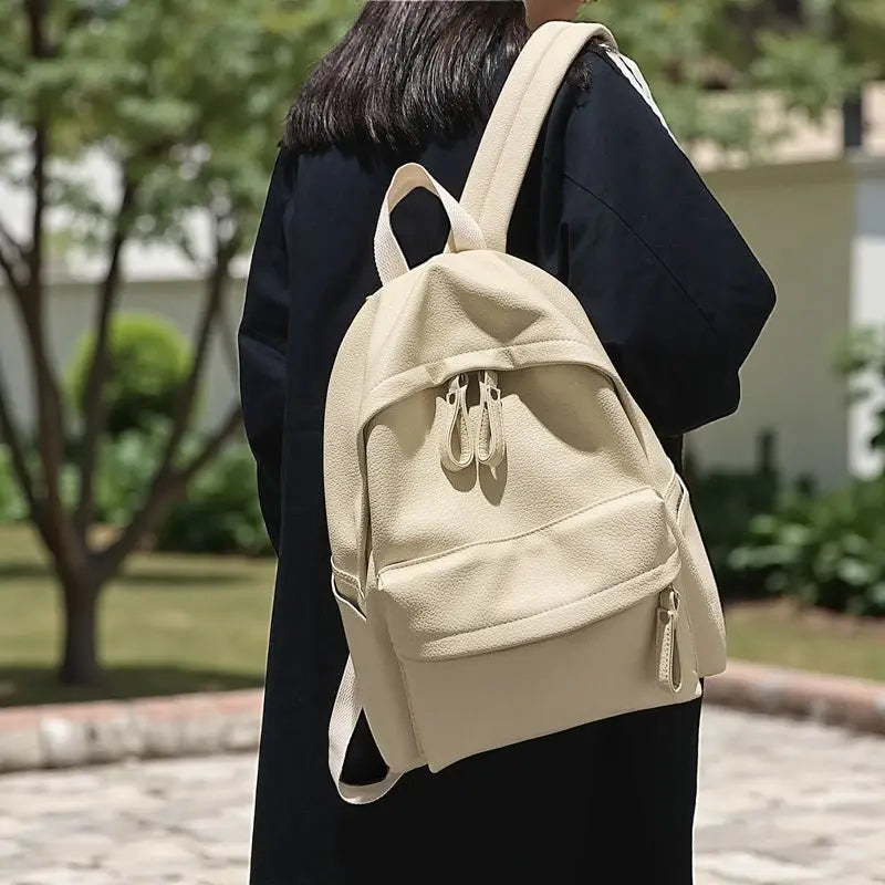 Sac à dos en cuir PU crème imperméable porté à l’épaule par une femme
