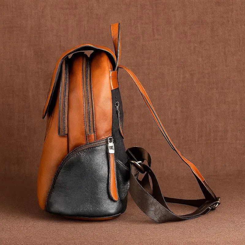 Vue de côté du sac à dos en cuir de vachette brun avec motif floral ethnique et détails noirs