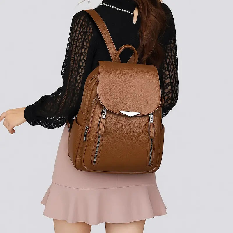 Sac à dos femme en cuir synthétique marron porté avec une tenue citadine