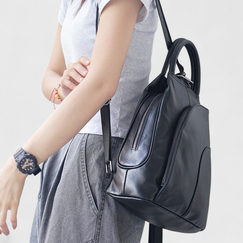 Vue de profil d’un sac à dos en cuir de vachette noir porté sur une épaule