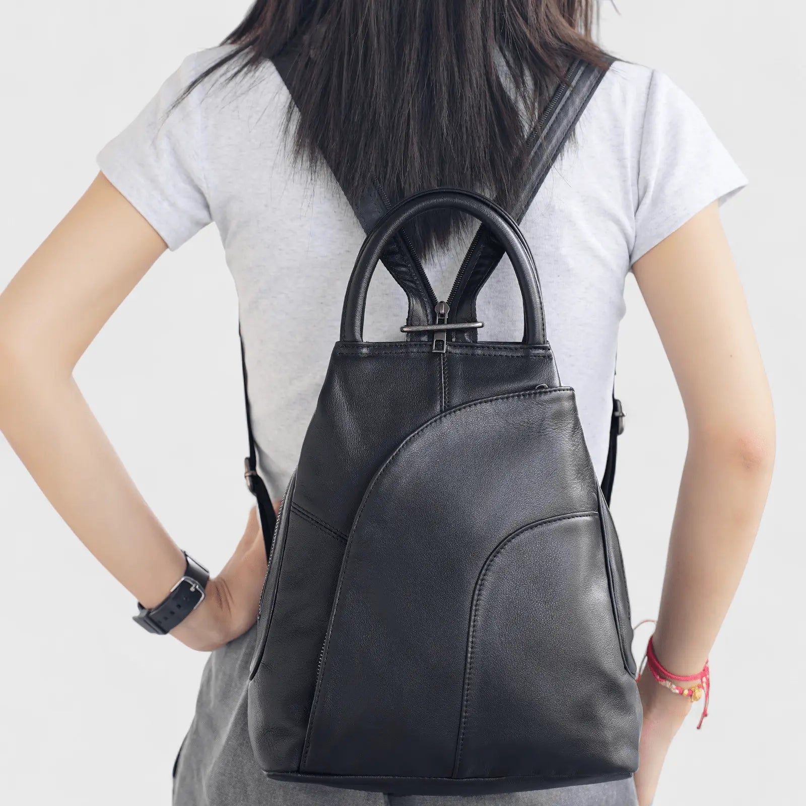 Vue arrière du sac à dos en cuir de vachette noir porté par une femme