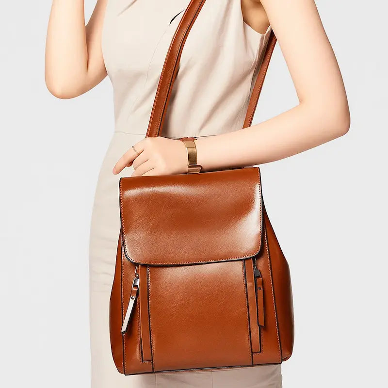 Sac à dos femme en cuir véritable marron porté à l’épaule par une femme