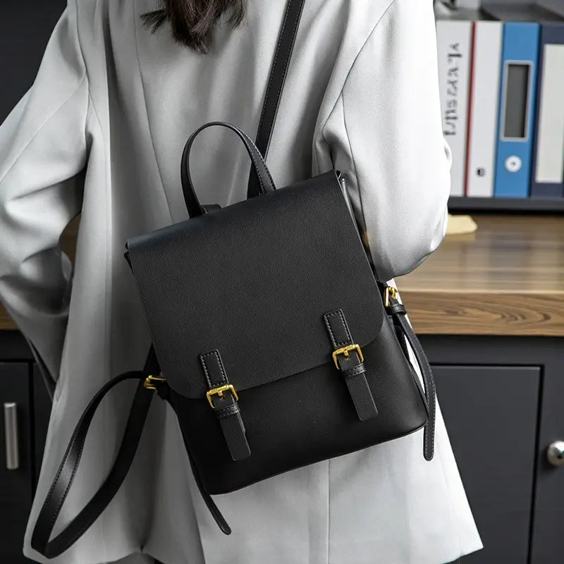 Sac à dos noir porté sur une veste grise vu de dos