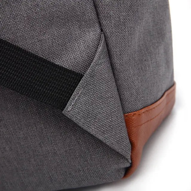 Coin inférieur du sac à dos gris renforcé par empiècement marron