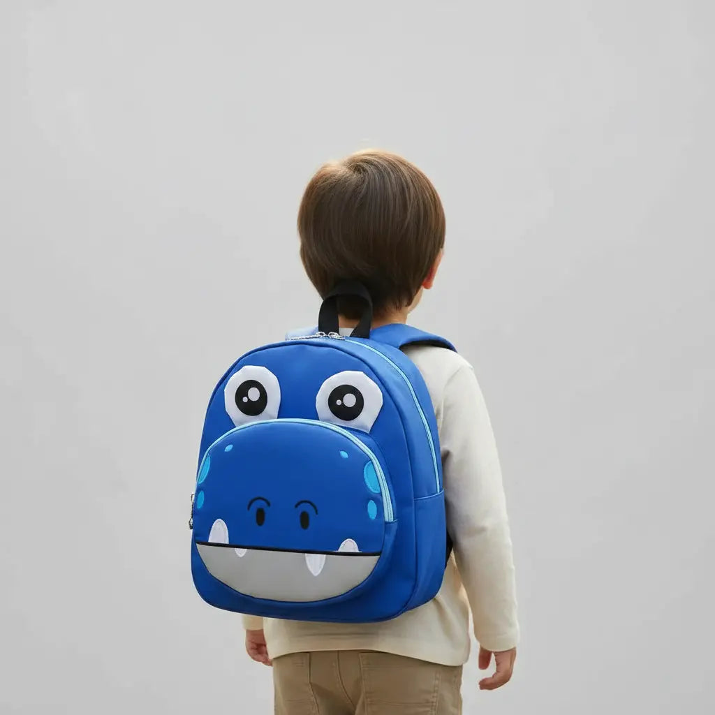 Enfant portant un sac à dos hippopotame bleu pour maternelle en photo studio