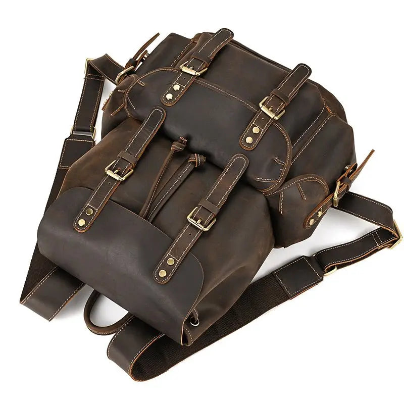 Sac à dos homme en cuir véritable vintage marron posé sur le côté