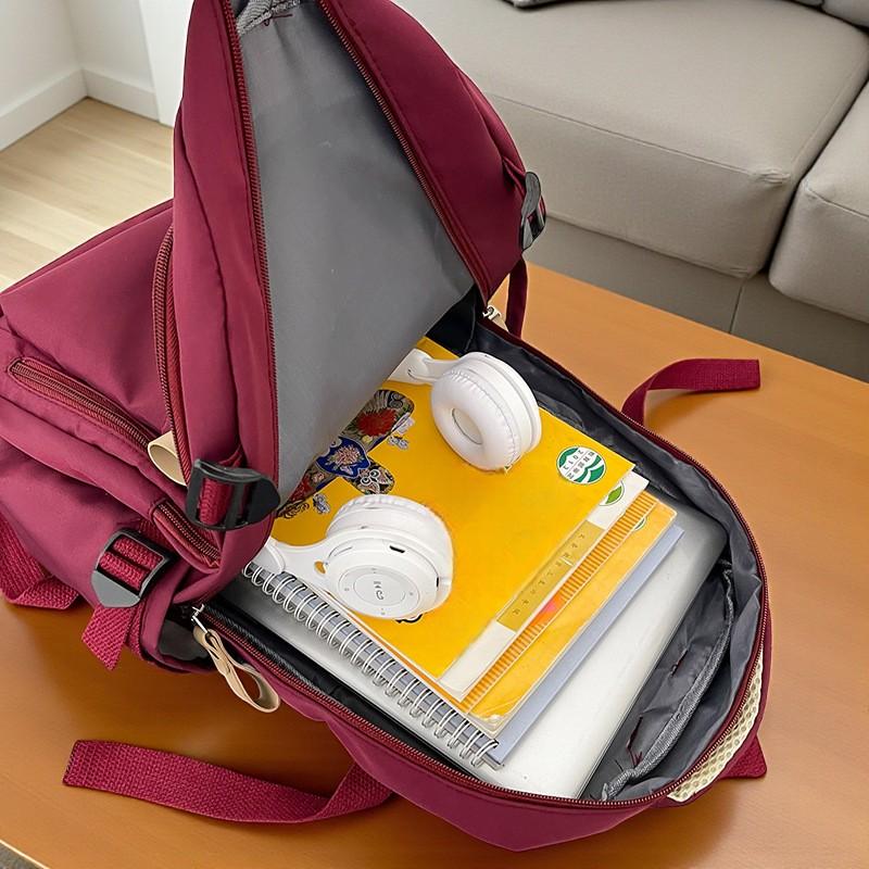 Intérieur du sac à dos lycéen bordeaux avec rangements ouverts
