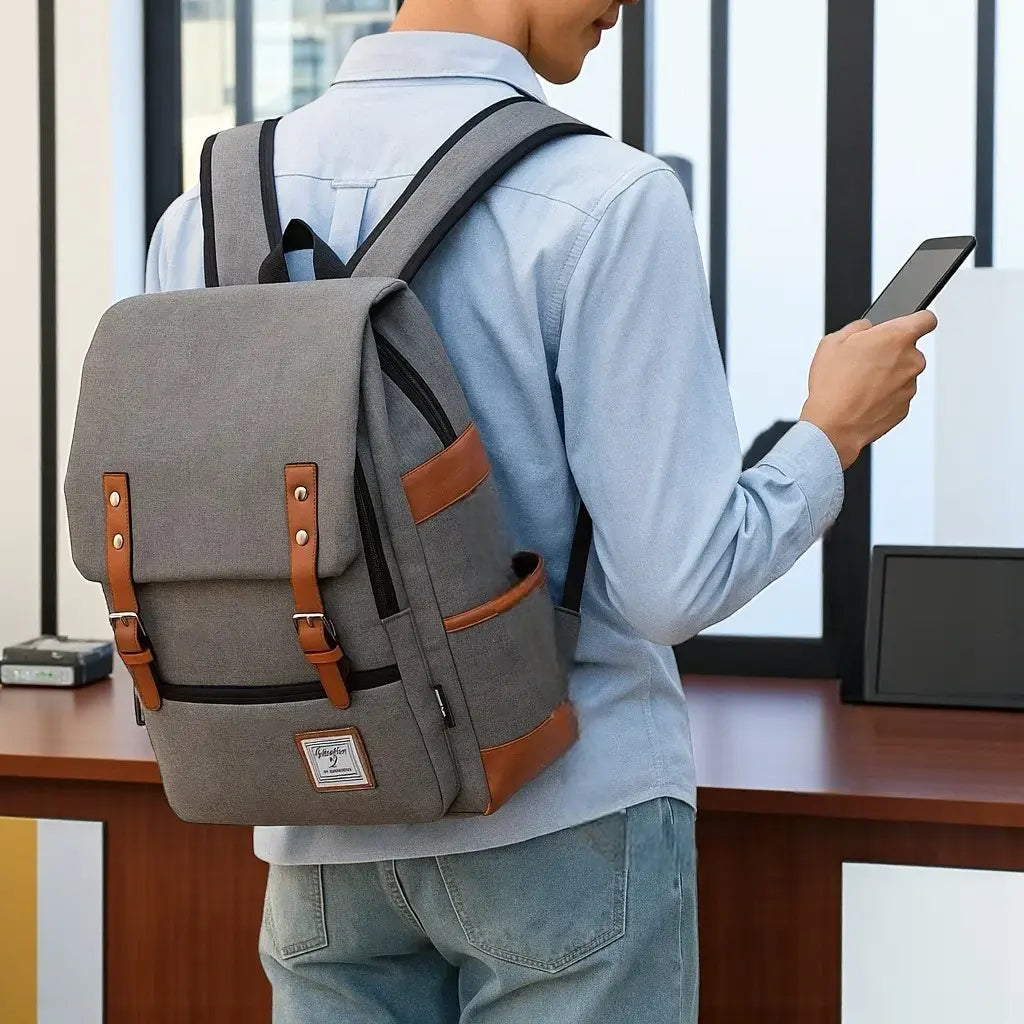 Sac à dos pour lycéen gris avec rabat et sangles marron, porté en extérieur.