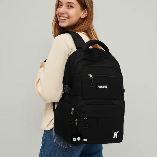 Étudiante portant un sac à dos noir grande capacité au style sobre et moderne.