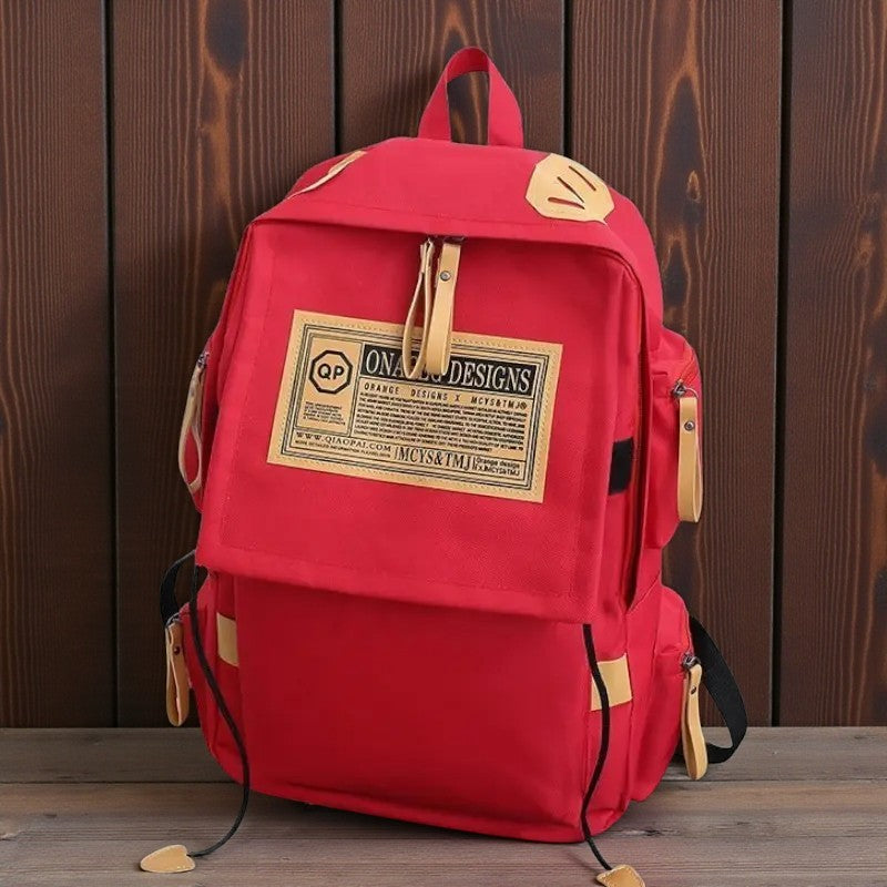 Sac à dos lycéen rouge multipoche posé sur un fond en bois
