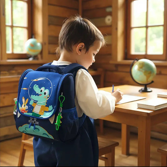 Sac à dos maternelle motif crocodile cosmonaut bleu porté par un enfant.