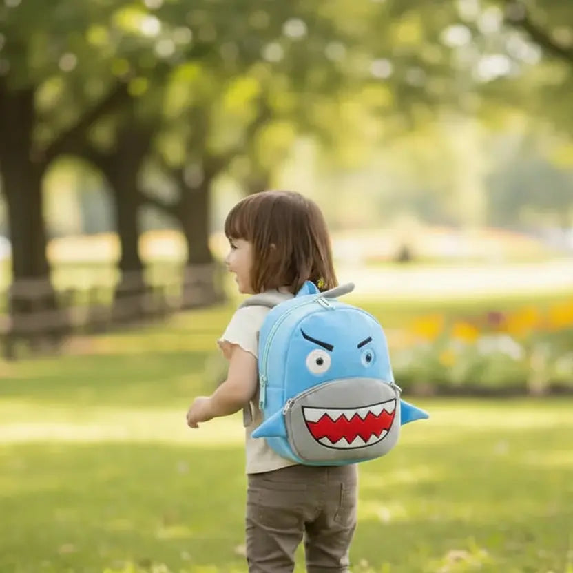 Sac à dos maternelle en peluche requin porté par un enfant en extérieur