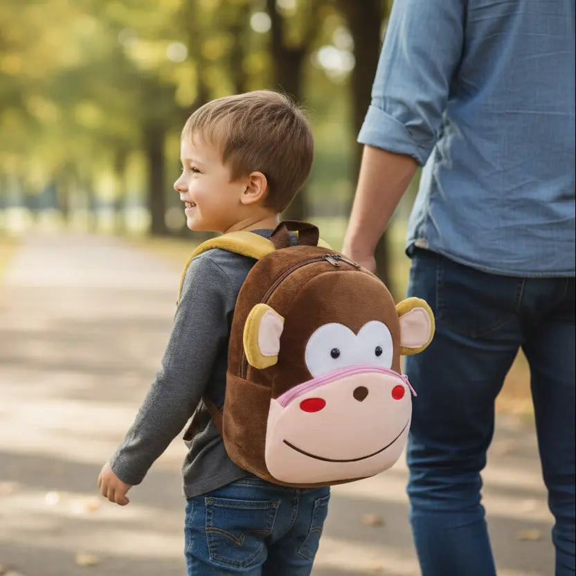 Enfant portant un sac à dos maternelle en peluche singe en extérieur