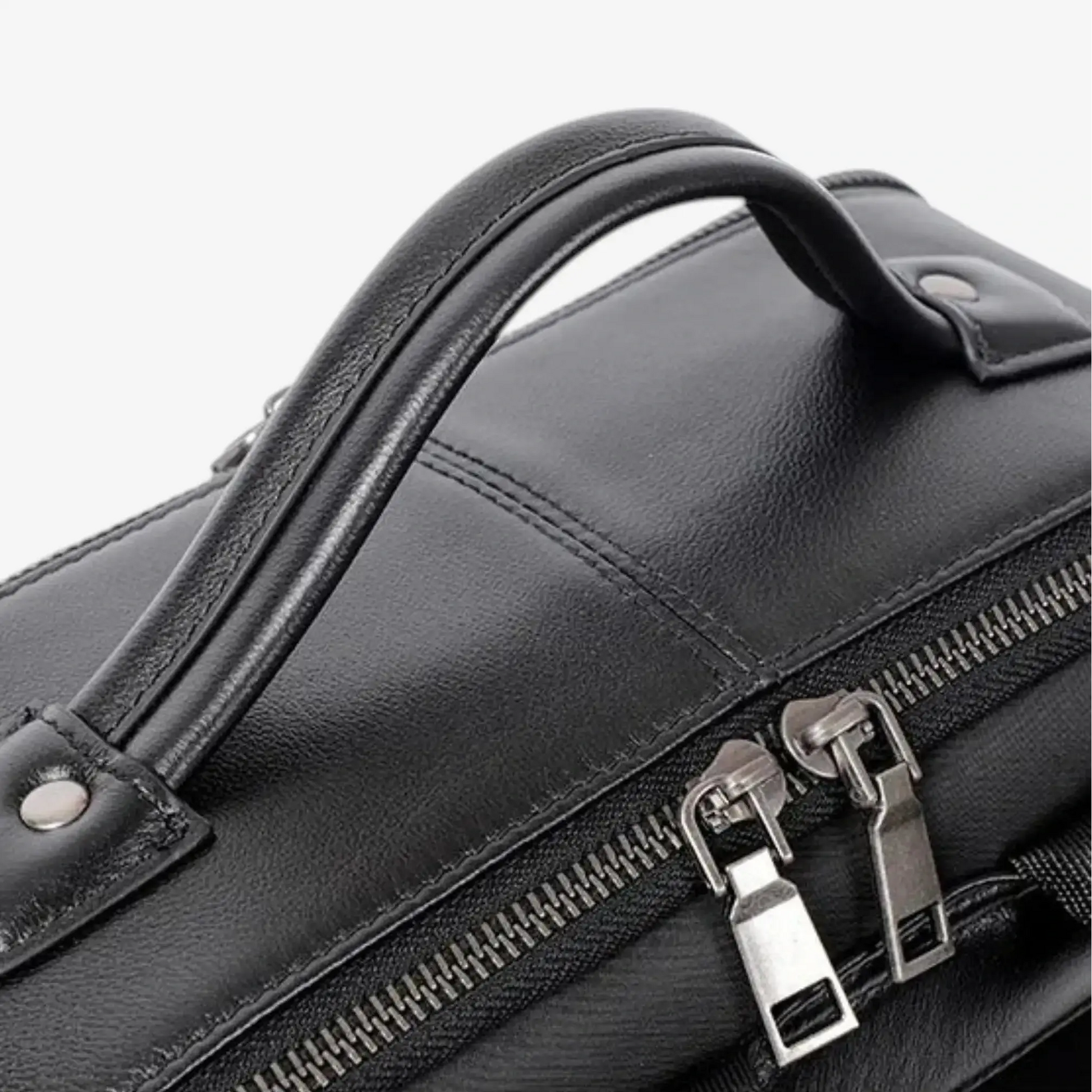 Détail de la poignée renforcée du sac à dos ordinateur en cuir noir pour homme