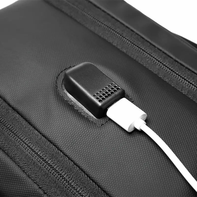 Gros plan sur le port USB du sac à dos noir, pratique pour recharger ses appareils.