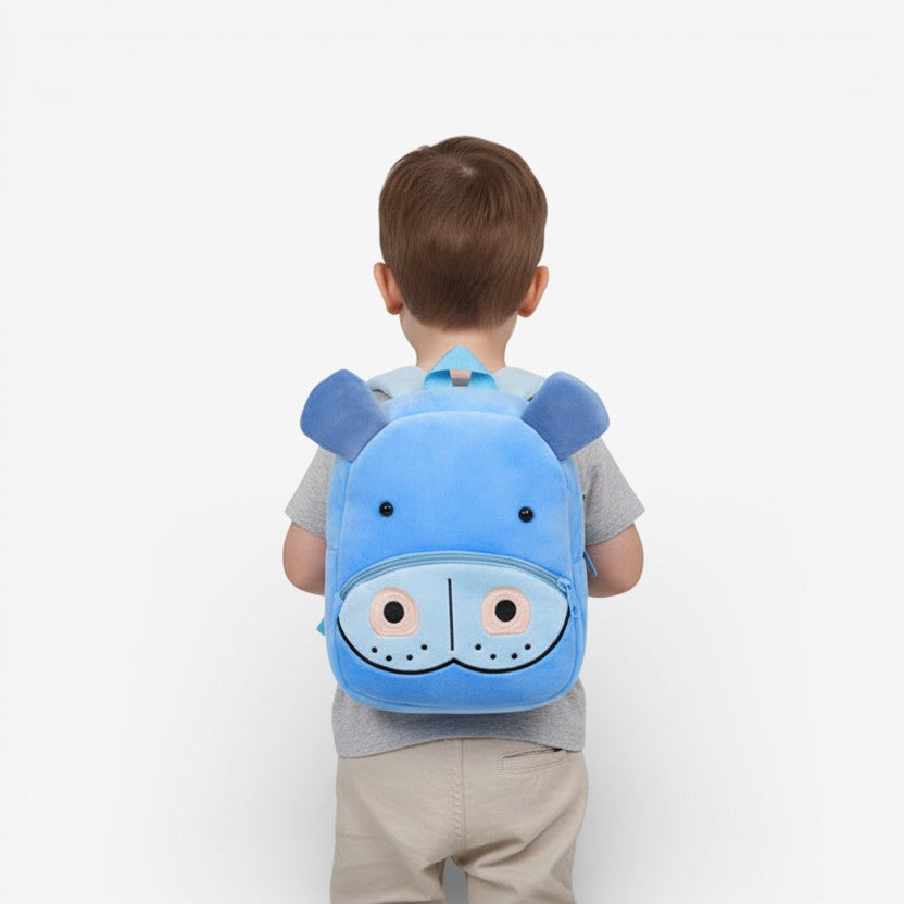 Sac à dos peluche hippopotame bleu porté par un enfant en maternelle