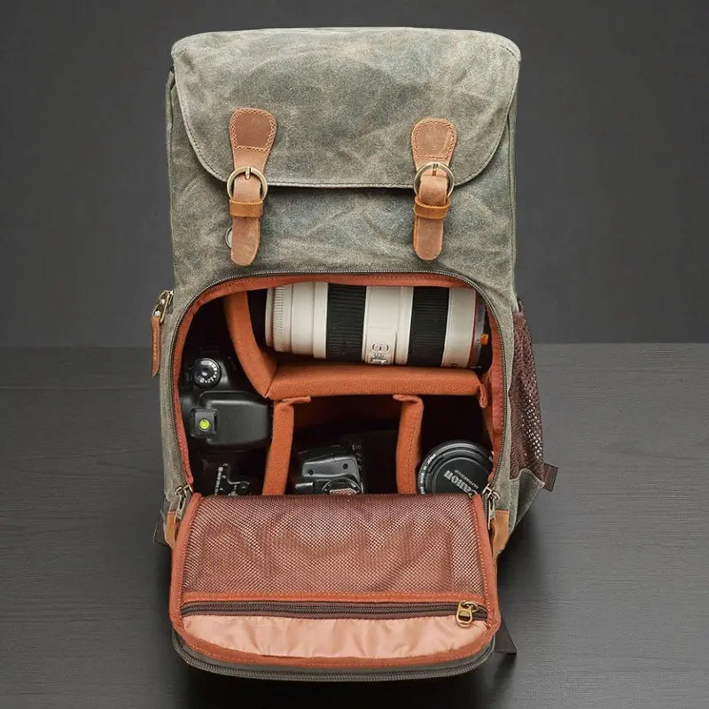 Sac à dos photo en toile verte ouvert avec boîtier reflex et objectifs rangés