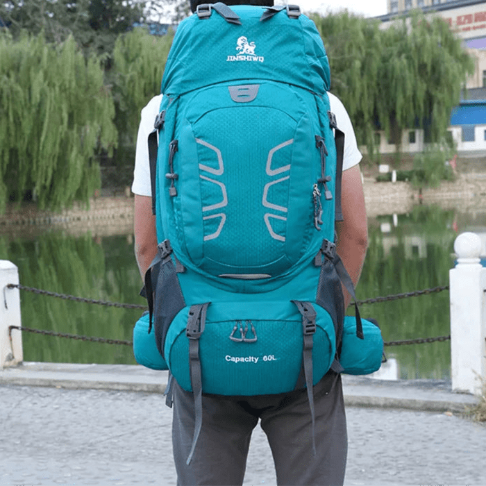 Sac à dos de randonnée 60L turquoise porté sur le dos par un randonneur, vue extérieure arrière