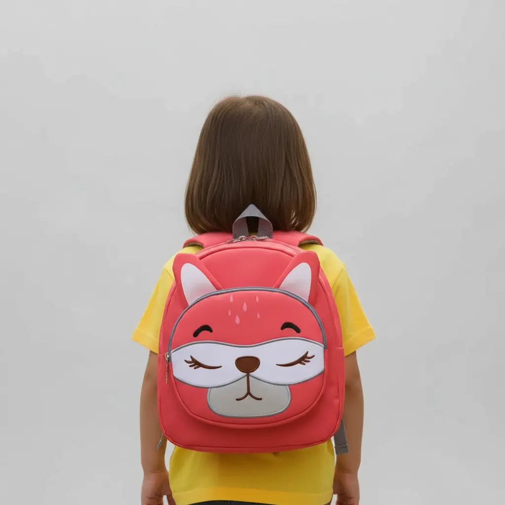 Enfant portant un sac à dos renard rose pour maternelle en photo studio