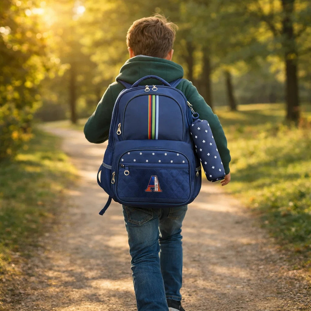 Garçon de dos portant un sac à dos scolaire bleu avec trousse étoilée en extérieur.