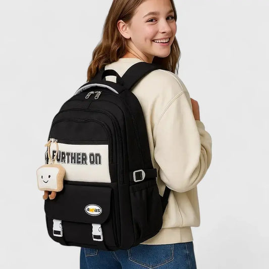 sac à dos scolaire multi poche de couleur noir porté sur le dos  par une collégienne.