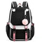 Sac à dos scolaire noir et blanc avec port USB et pompon décoratif, vue de face.